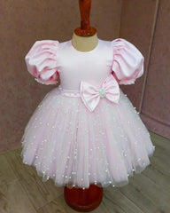 Front view of a pink puff sleeve pearl dress for girls, showcasing elegant pearl details and a voluminous tulle skirt.