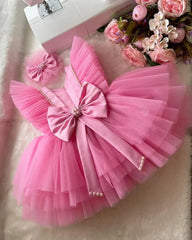 Back view of a pink tiered tulle dress with a layered design, perfect for birthdays and special occasions.