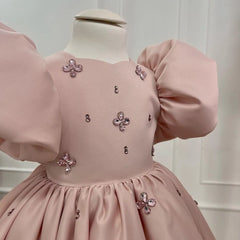 Side view of the pink gown for girls with puffy sleeves, highlighting its layered design and royal charm.