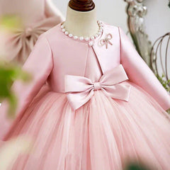Close-up of double-bow front and delicate satin coat on princess birthday dress in pink.