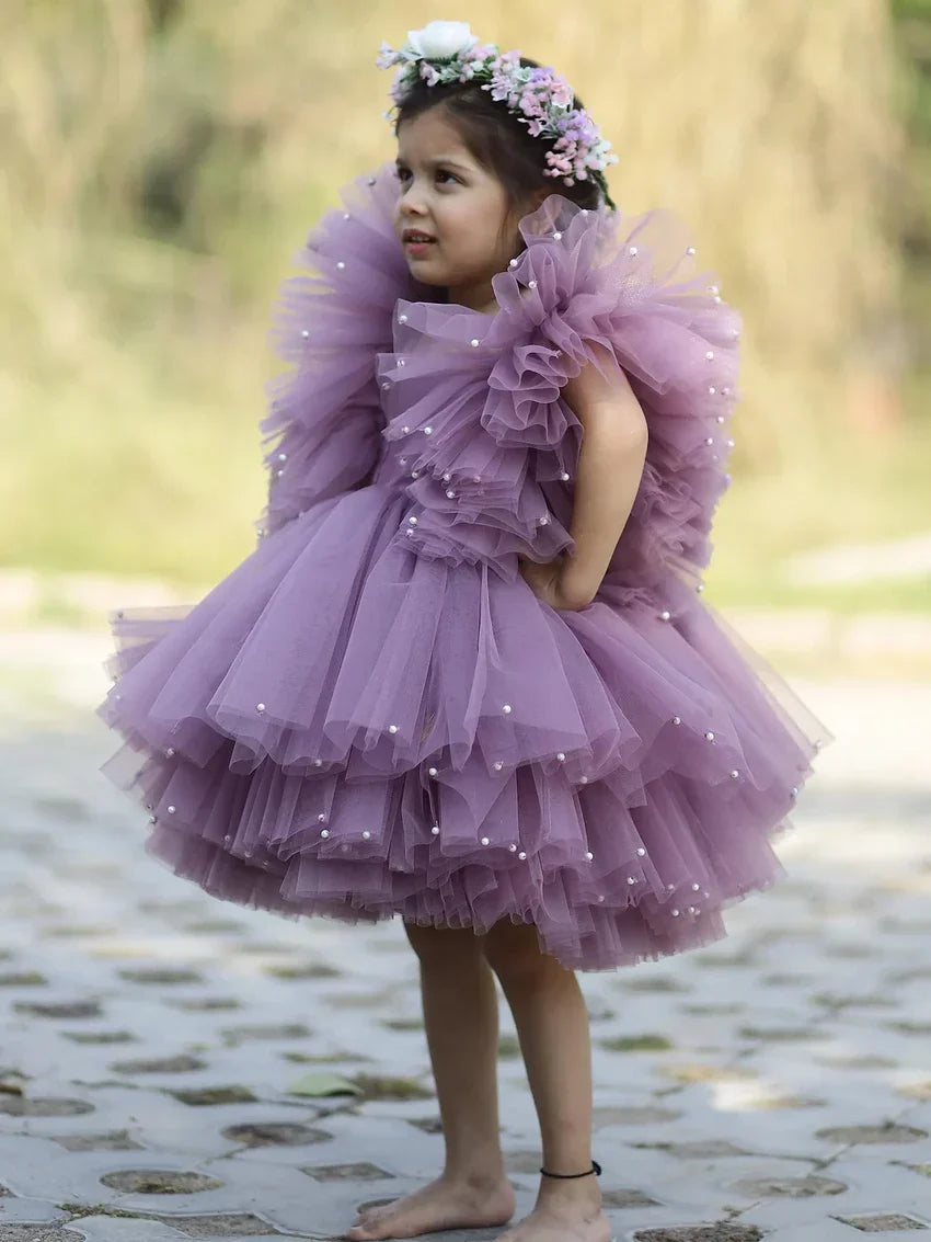 Side view of girls’ lavender princess gown with puffy tulle and pearl accents.