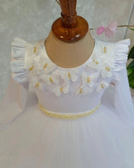 Close-up of butterfly and floral details on white luxury dress for girls.