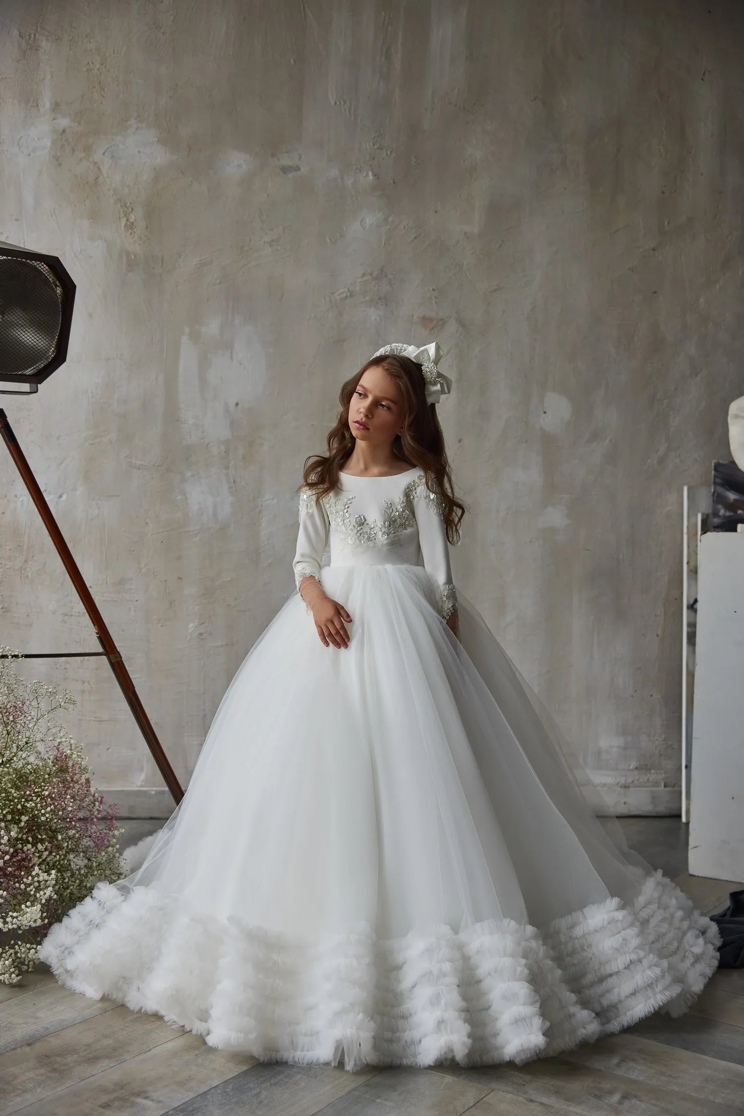 Front view of White Lace Flower Girl Dress with long sleeves and ruffled hem